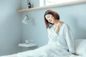 寝起きの女性_首回りを揉む